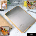 Cutting board in kitchen environment highlighting wooden frame and stainless steel surface