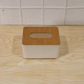 Bamboo tissue box holder on a modern office desk next to a laptop.