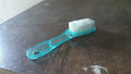 Plastic scrubbing brush featuring an ergonomic handle design.